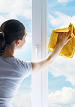 A woman cleaning the outside of a window.